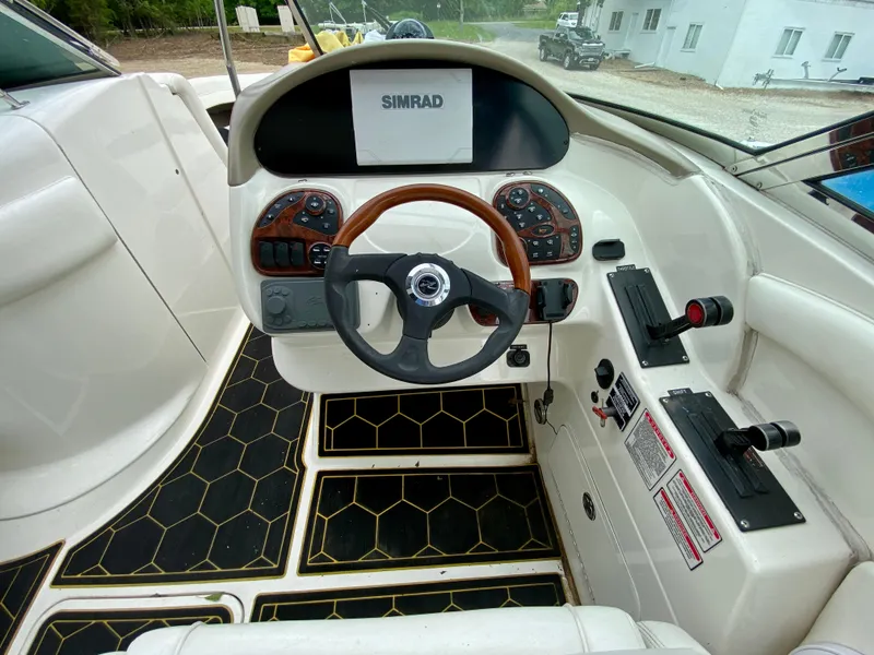 Slide: The Image of Interior view of 2004 Sea Ray 290 SLX boat cockpit with steering wheel and controls. - 12