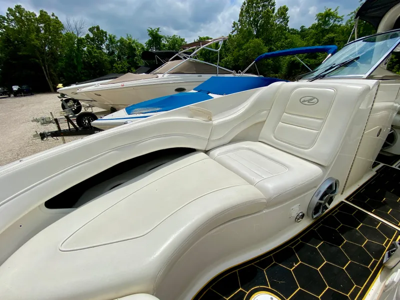 Slide: The Image of 2004 Sea Ray 290 SLX boat with white leather seating, parked outdoors. - 19
