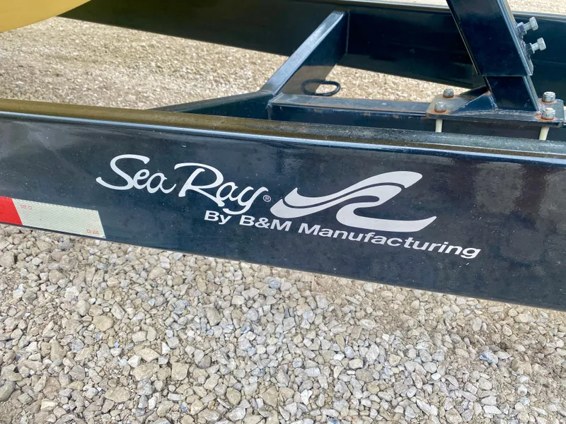 Slide: The Image of Trailer with Sea Ray branding by B&M Manufacturing, gravel background. - 24