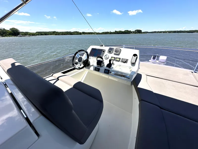 Slide: The Image of Flybridge of 2017 Prestige 500 yacht with helm station overlooking serene waters. - 13