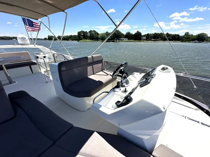 Slide: The Image of Flybridge of 2017 Prestige 500 yacht with helm, seating, and water view. - 14