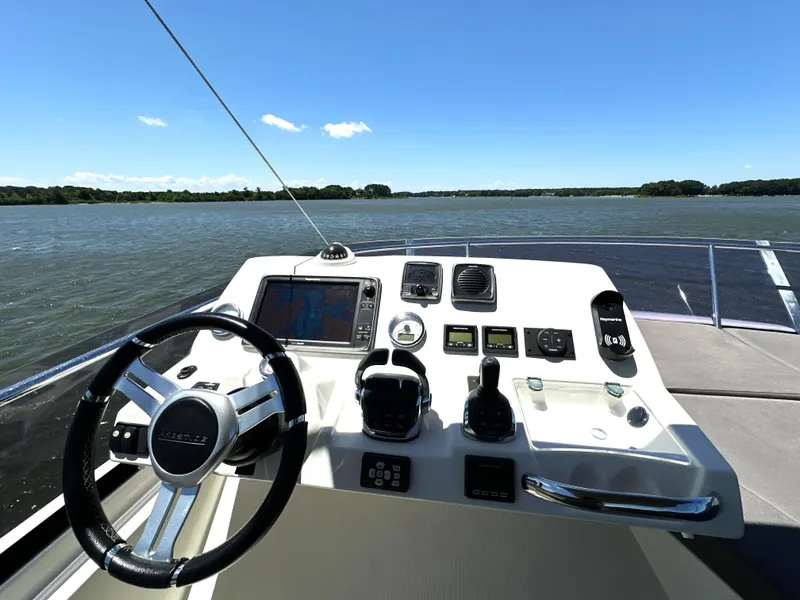 Slide: The Image of Helm of 2017 Prestige 500 yacht with navigational controls on a sunny day. - 15