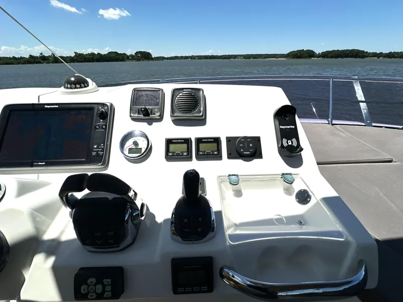 Slide: The Image of Control panel of a 2017 Prestige 500 yacht with navigation equipment, overlooking a serene water view. - 17