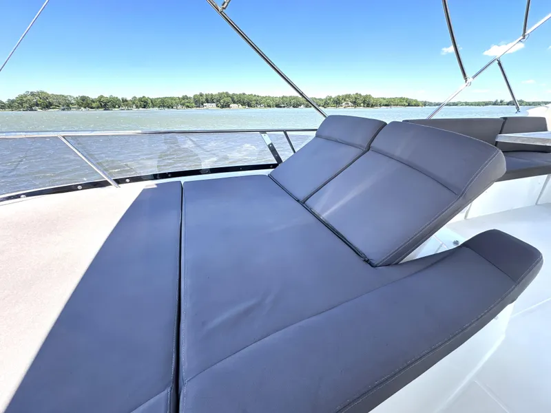 Slide: The Image of Luxurious sunbed on 2017 Prestige 500 yacht, overlooking serene waters and lush shoreline. - 21