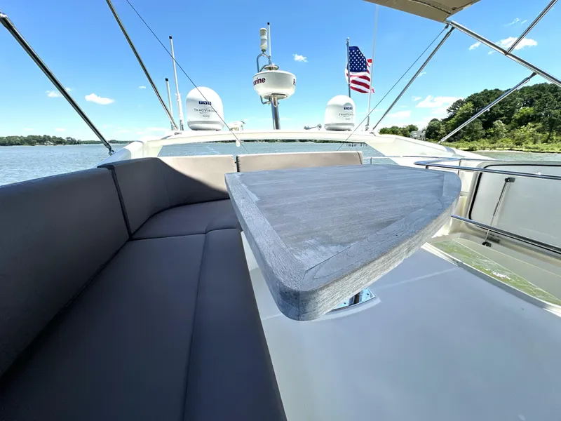 Slide: The Image of Luxury 2017 Prestige 500 yacht deck with seating, table, and American flag. - 29