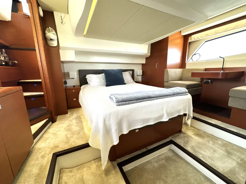 Slide: The Image of Luxurious 2017 Prestige 500 yacht bedroom with cozy bed, elegant wood finishes, and ample natural light. - 3