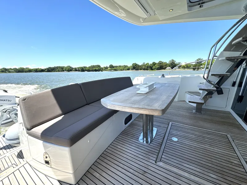 Slide: The Image of Prestige 500 yacht deck with seating, table, and scenic water view, 2017 model. - 37