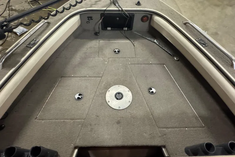 Slide: The Image of 2004 Alumacraft Trophy 175 boat interior with carpeted deck and storage compartments. - 15