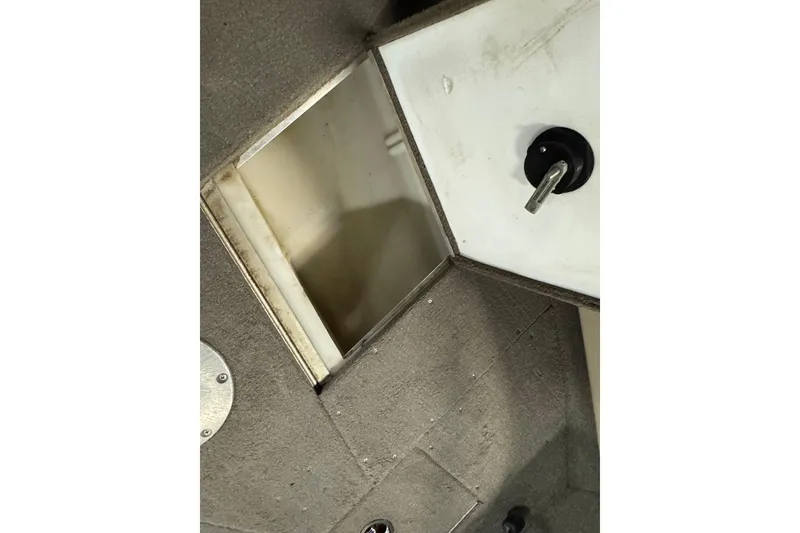 Slide: The Image of 2004 Alumacraft Trophy 175 boat interior storage compartment with open hatch. - 17