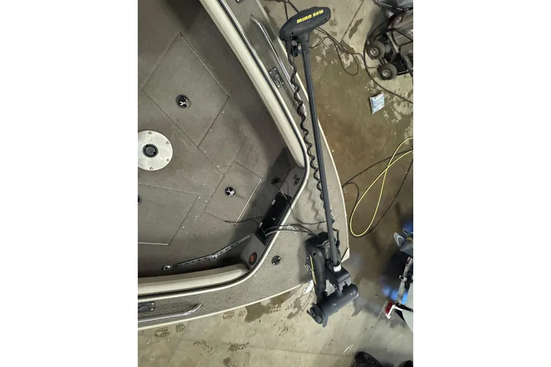 Slide: The Image of 2004 Alumacraft Trophy 175 boat interior with trolling motor on a workshop floor. - 18