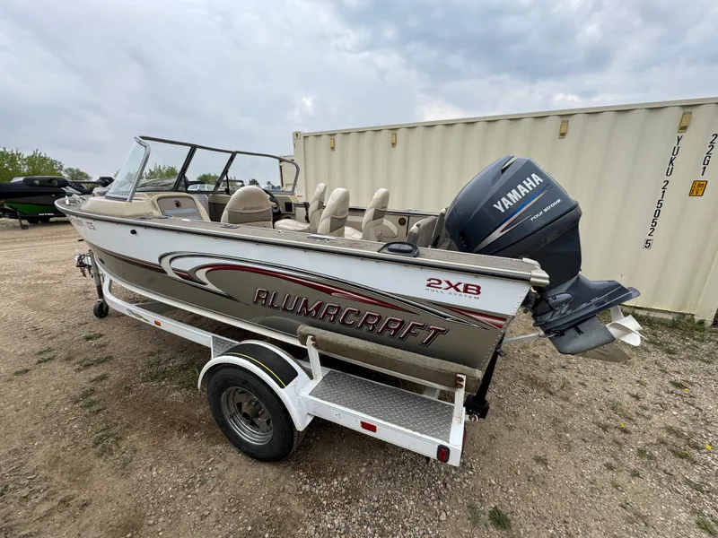 Slide: The Image of 2004 Alumacraft Trophy 175 boat with Yamaha outboard motor in a garage setting. - 4