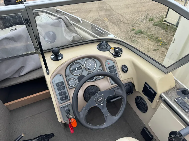 Slide: The Image of 2004 Alumacraft Trophy 175 boat interior with steering wheel and beige seats. - 8