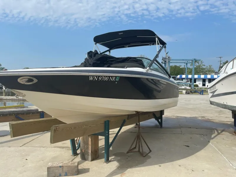 The Image of 2005 Cobalt 246 boat on a stand, marina background, clear sky. - 0