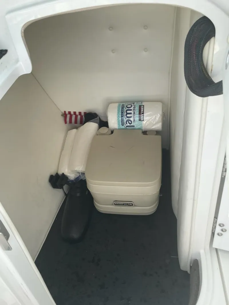 Slide: The Image of Storage compartment in a 2005 Cobalt 246 boat with supplies and portable toilet. - 10