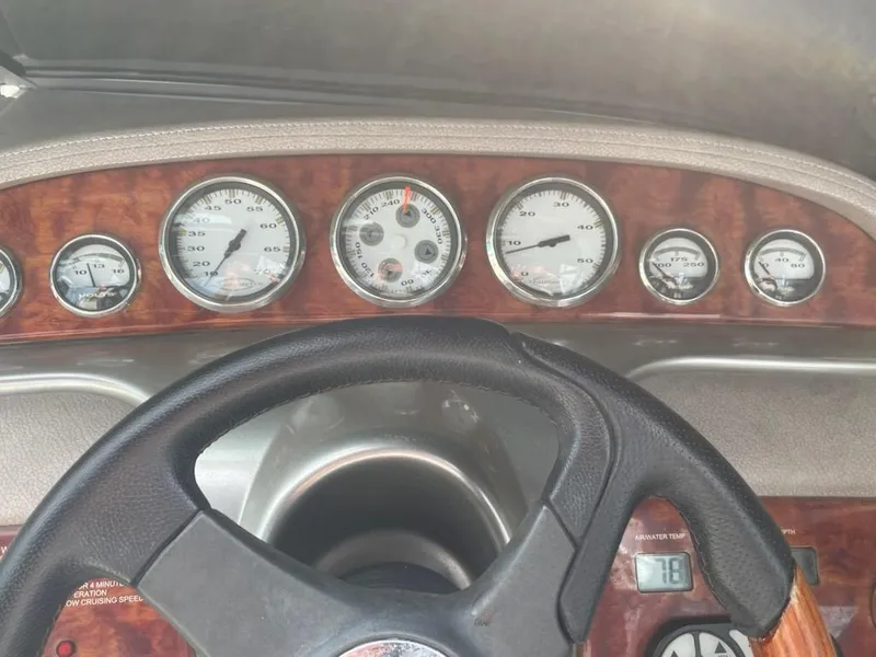 Slide: The Image of Dashboard of a 2005 Cobalt 246 boat with wood paneling and multiple gauges. - 12