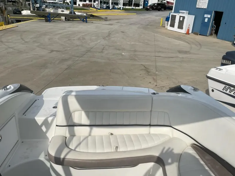 Slide: The Image of 2005 Cobalt 246 boat interior with white seating at a marina. - 13