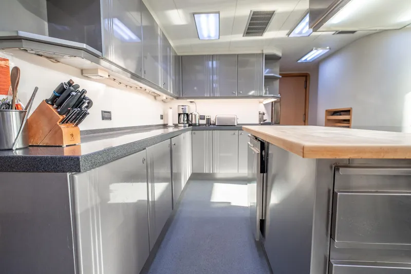 Slide: The Image of Modern kitchen interior on 1996 Cheoy Lee 145 Global Series yacht, featuring sleek cabinetry and countertops. - 48