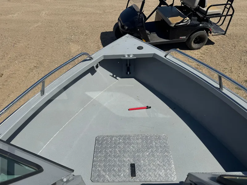 Slide: The Image of 2017 Smoker Craft 202 Phantom boat deck with metal hatch and nearby golf cart. - 12