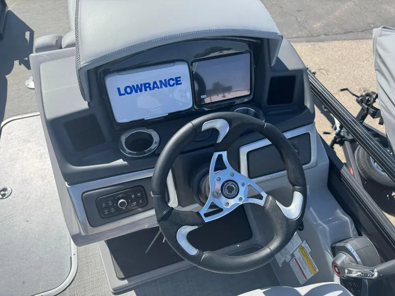 Slide: The Image of 2024 Regency 230 DL3 boat dashboard with Lowrance display and steering wheel. - 11