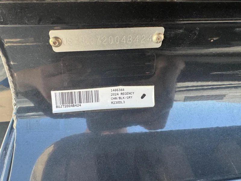 Slide: The Image of 2024 Regency 230 DL3 pontoon boat with Mercury engine in a warehouse setting. - 3