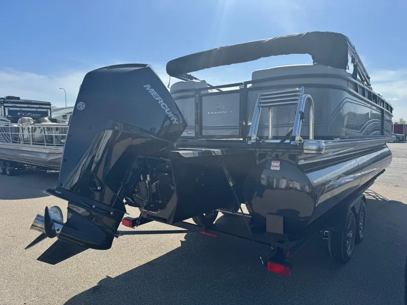 Slide: The Image of 2024 Regency 230 DL3 pontoon boat in a garage, featuring a powerful outboard motor. - 4