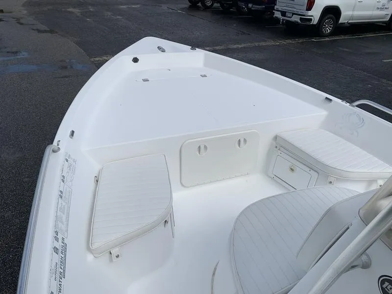 Slide: The Image of 2009 Sea King 198 Bay boat interior with white seating and storage compartments. - 15