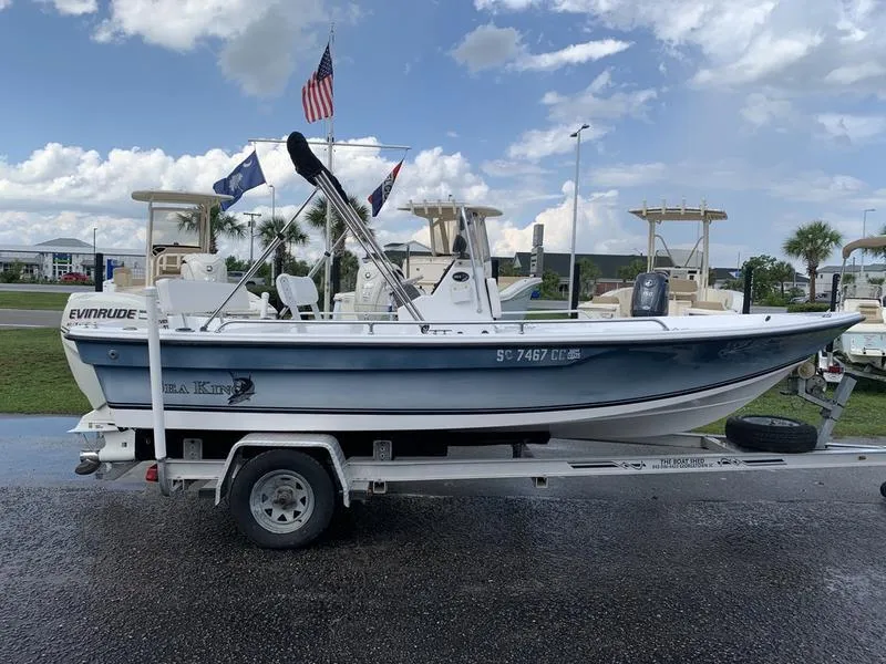 Slide: The Image of 2009 Sea King 198 Bay boat on trailer, parked outdoors under cloudy sky. - 5
