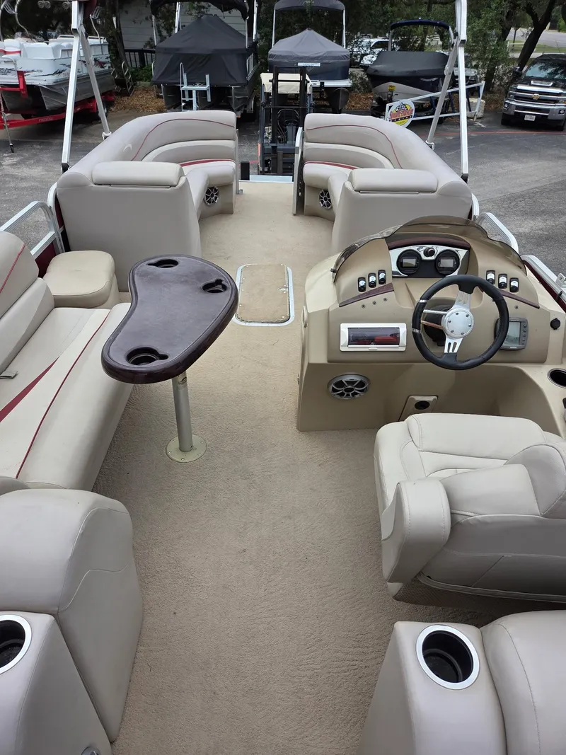 Slide: The Image of 2011 Bennington 2554GCW pontoon boat interior with beige seating and steering console. - 12