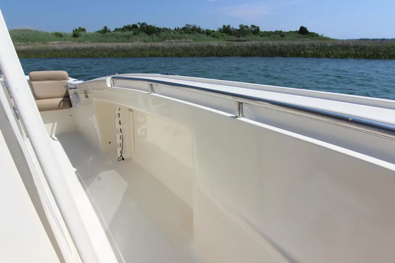 Slide: The Image of 2011 Scout 222 Sportfish boat interior with railing, on calm water. - 17