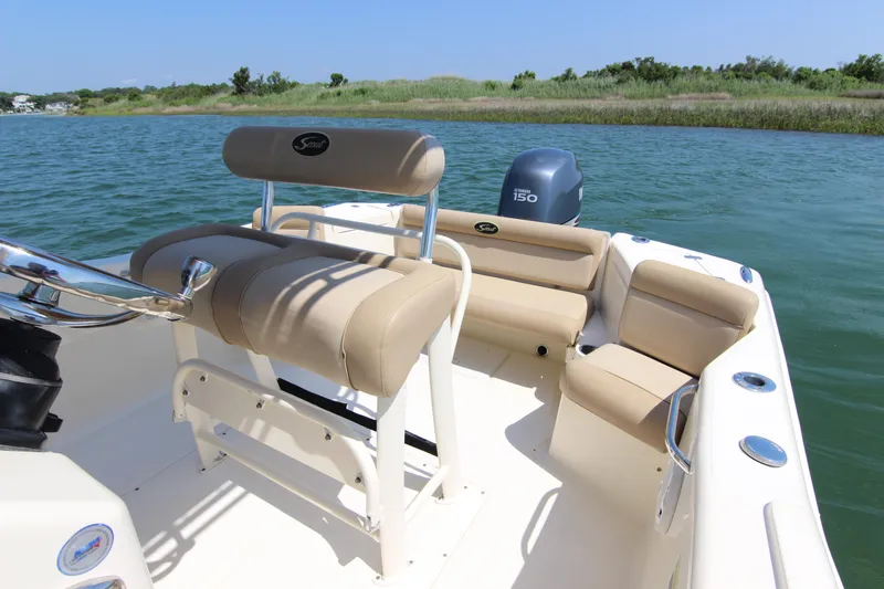 Slide: The Image of 2011 Scout 222 Sportfish boat with beige seating on calm water. - 18