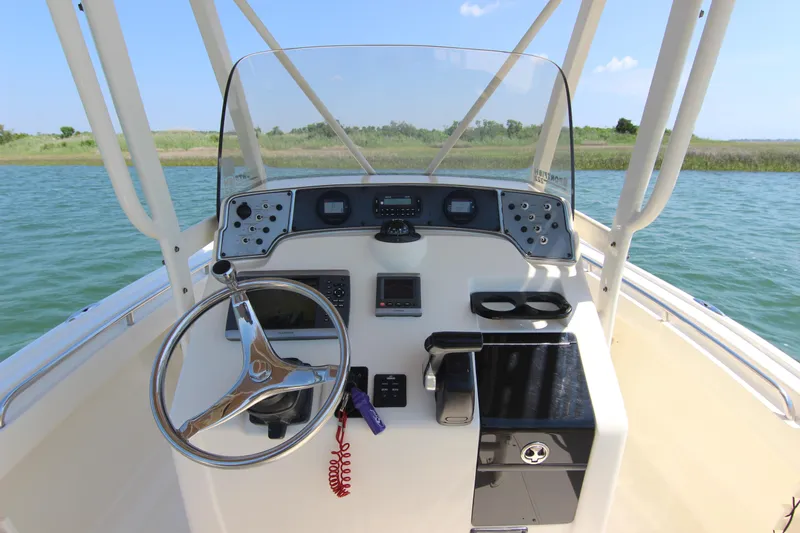 Slide: The Image of 2011 Scout 222 Sportfish boat console with steering wheel and controls on open water. - 20