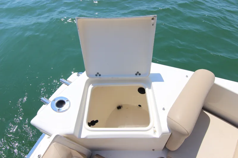 Slide: The Image of Open storage compartment on 2011 Scout 222 Sportfish boat, with beige seating and ocean backdrop. - 24