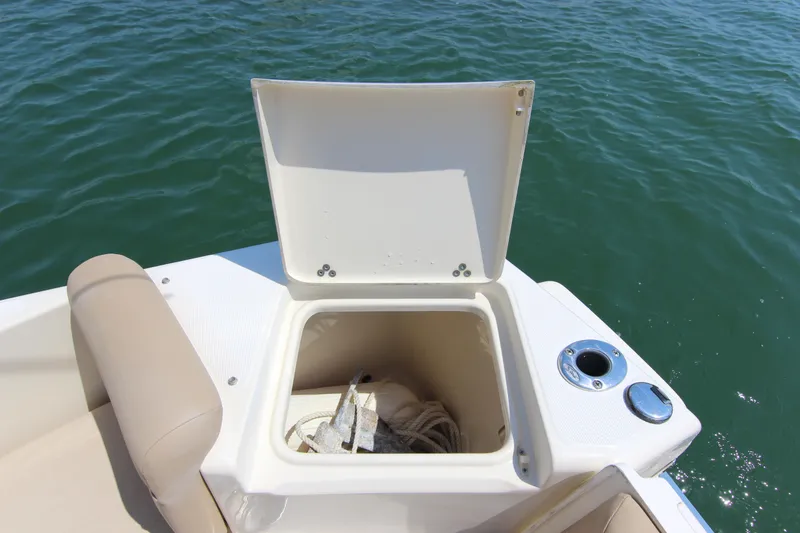 Slide: The Image of Open storage compartment on 2011 Scout 222 Sportfish boat, with ropes inside, near water. - 25