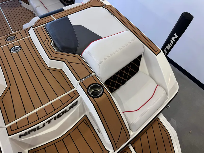 Slide: The Image of 2019 Nautique Super Air Nautique GS22 boat interior with brown decking and white seating. - 11