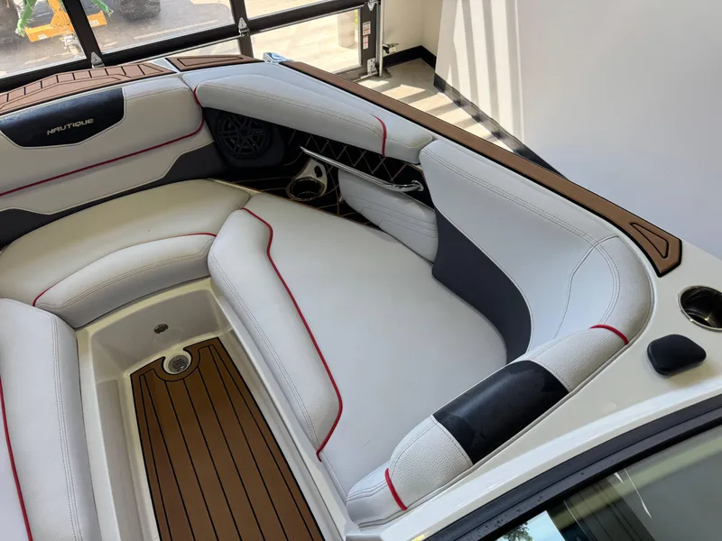 Slide: The Image of 2019 Nautique Super Air Nautique GS22 interior with white and red seating, wood accents. - 19