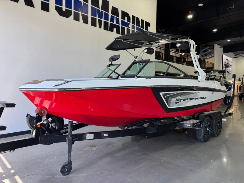 Slide: The Image of 2019 Nautique Super Air Nautique GS22 boat in showroom, red and white design. - 2