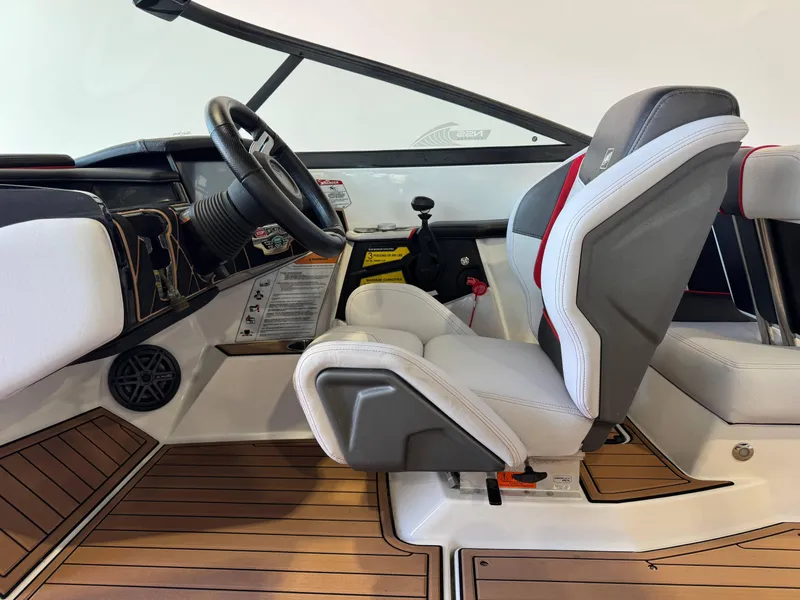 Slide: The Image of 2019 Nautique Super Air Nautique GS22 interior with steering wheel and captain's seat. - 24