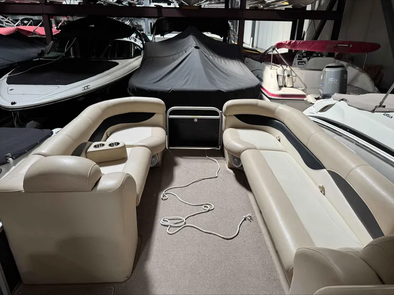 Slide: The Image of 2011 Godfrey Aqua Patio 240 pontoon boat interior with beige seating in storage. - 7