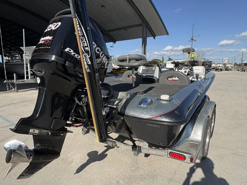 Slide: The Image of 2005 Bass Cat Cougar FTD boat with Mercury engine, parked outdoors under a canopy. - 8