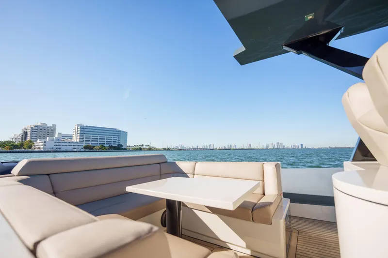 Slide: The Image of Luxurious 2019 Chaser 500R yacht with elegant seating, ocean view, and city skyline in the background. - 13