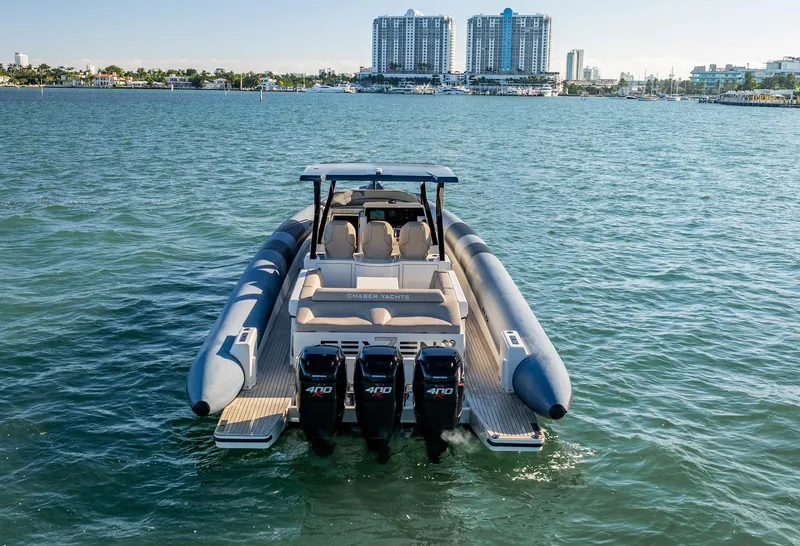 Slide: The Image of 2019 Chaser 500R boat with triple engines on open water, city skyline in background. - 14