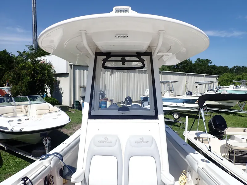 Slide: The Image of 2020 Regulator 23 boat with T-top, docked among other boats. - 10