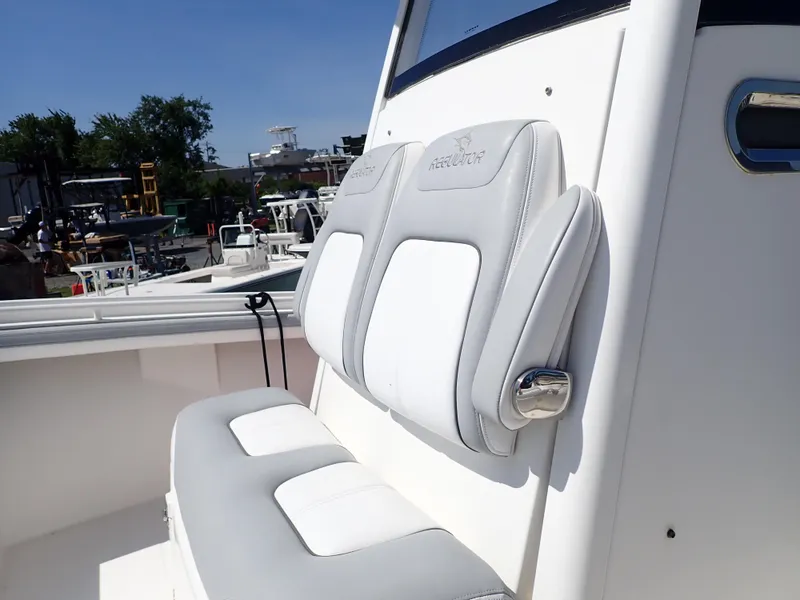 Slide: The Image of 2020 Regulator 23 boat with white and gray cushioned seating, outdoor marina setting. - 14