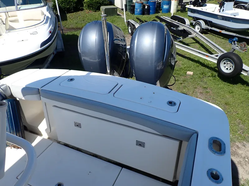 Slide: The Image of 2020 Regulator 23 boat with dual outboard motors, parked on grass near trailers. - 15