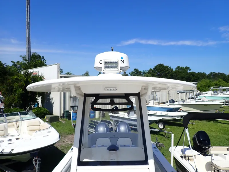 Slide: The Image of 2020 Regulator 23 boat with radar, parked outdoors under clear blue sky. - 17