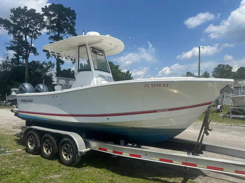 Slide: The Image of 2020 Regulator 23 boat on trailer under clear blue sky. - 2