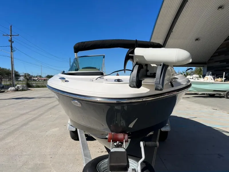 Slide: The Image of 2017 Chaparral H20 boat on trailer, parked outdoors under clear blue sky. - 19