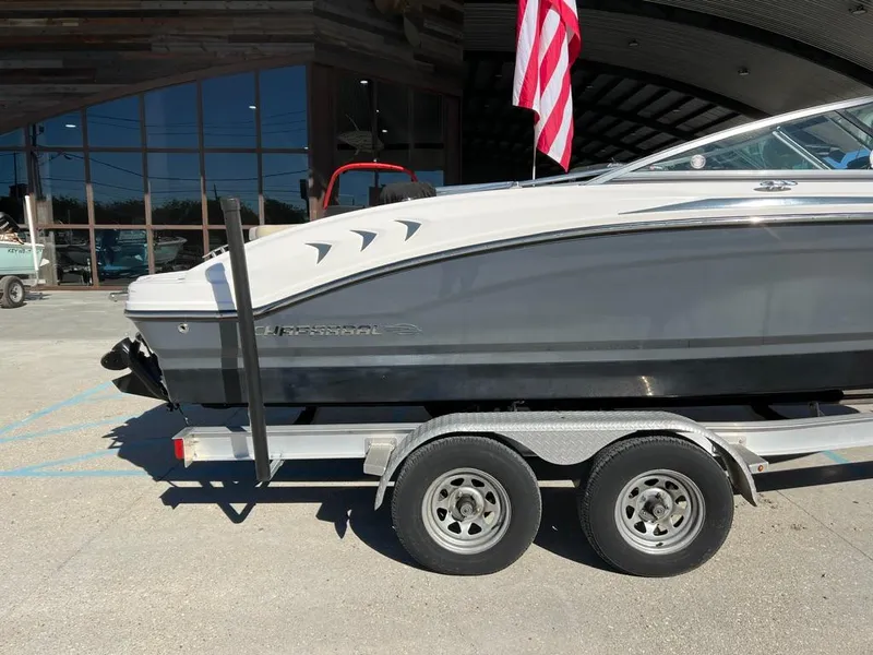 Slide: The Image of 2017 Chaparral H20 boat on trailer, parked outdoors with American flag. - 2