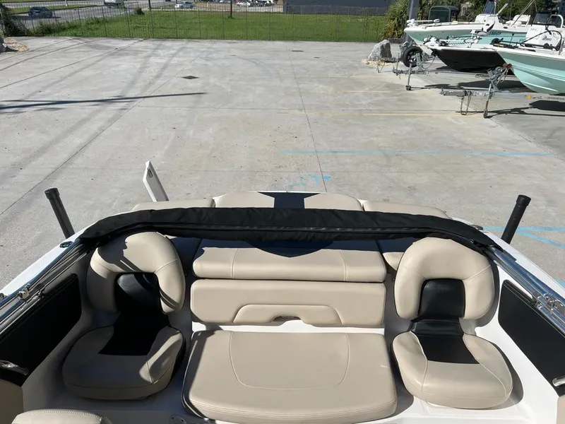 Slide: The Image of 2017 Chaparral H20 boat interior with beige seating, parked in a marina. - 9