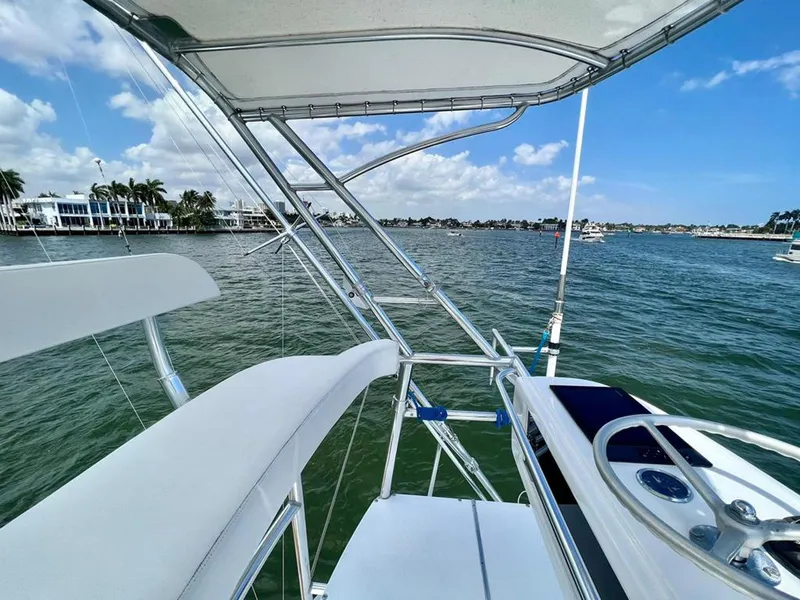 Slide: The Image of 1999 Gamefisherman 34 Express boat on water, clear sky, coastal view. - 15